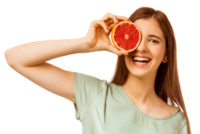 Young woman holding grapefruit in front of her eye